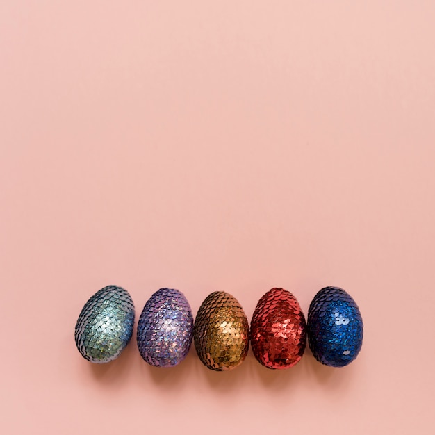 Foto gratuita huevos de pascua brillantes en mesa