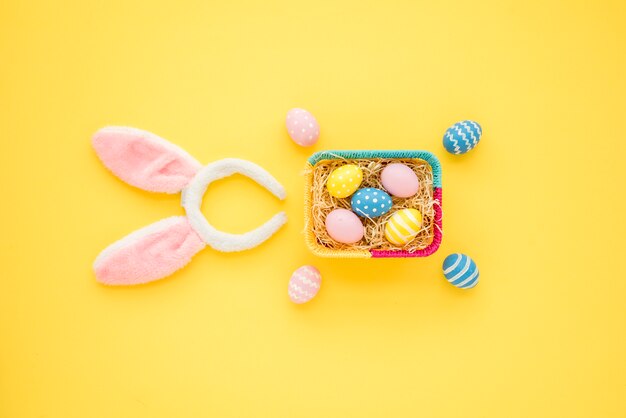 Huevos de Pascua en canasta con orejas de conejo