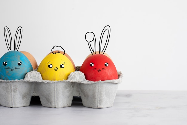 Foto gratuita huevos de pascua con caras graciosas pintadas