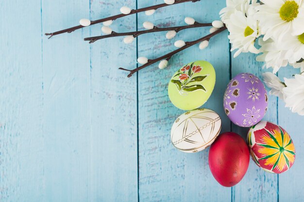 Foto gratuita huevos de pascua cerca de chamomiles y pussy willow