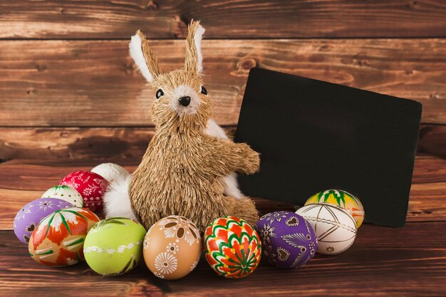 Huevos de Pascua cerca de conejo juguete con papel