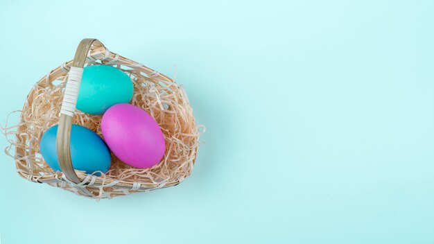 Huevos de Pascua en cesta sobre mesa