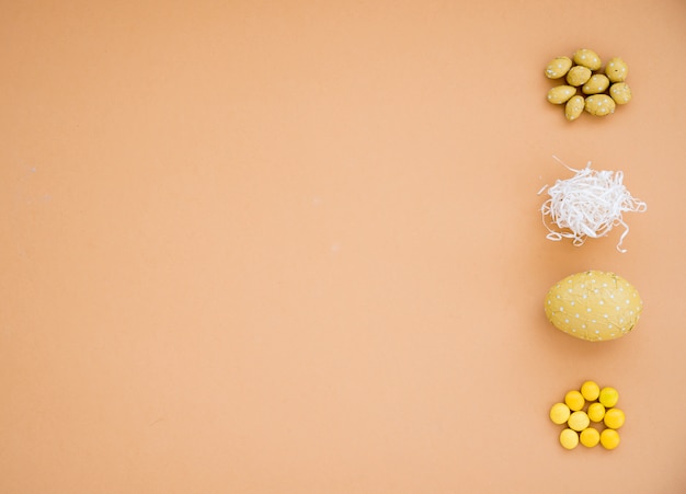 Foto gratuita huevos de pascua de chocolate con pequeños caramelos en mesa