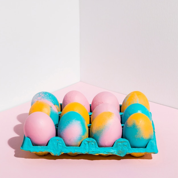 Foto gratuita huevos de pascua coloreados en estante brillante en la tabla