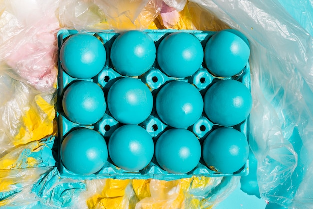 Foto gratuita huevos de pascua coloridos en estante en celofán pintado