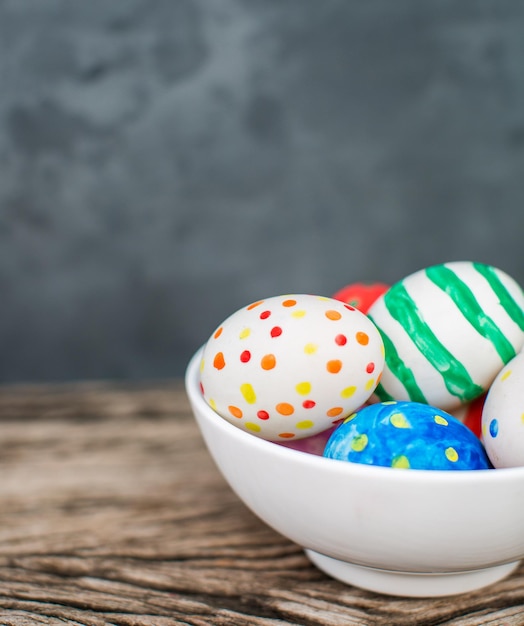 Foto gratuita huevos de pascua coloridos y en mesa de madera