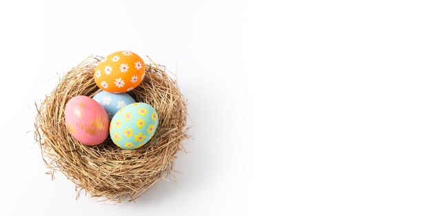 Huevos de Pascua coloridos en nido sobre fondo de espacio de copia en blanco