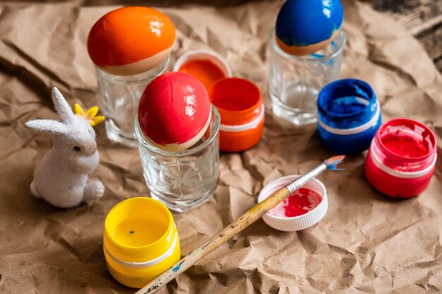 Huevos de Pascua decorados en diversos colores en primer plano del conejo de Pascua y acuarelas