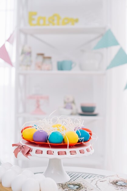 Huevos de Pascua decorativos frente a estante decorativo borroso
