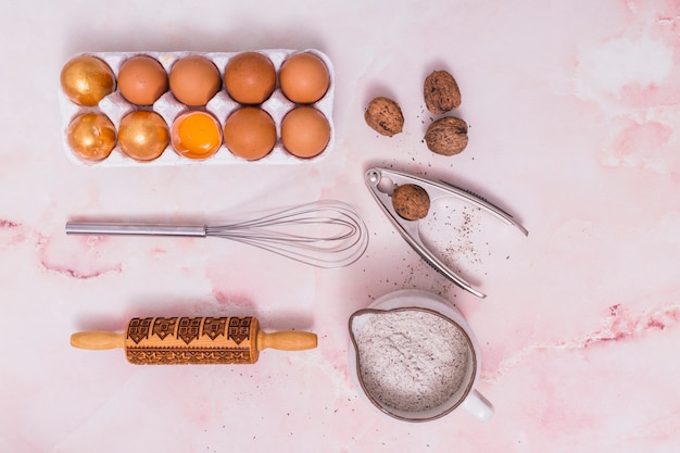 Foto gratuita huevos de pascua dorados en estante con utensilios de cocina.