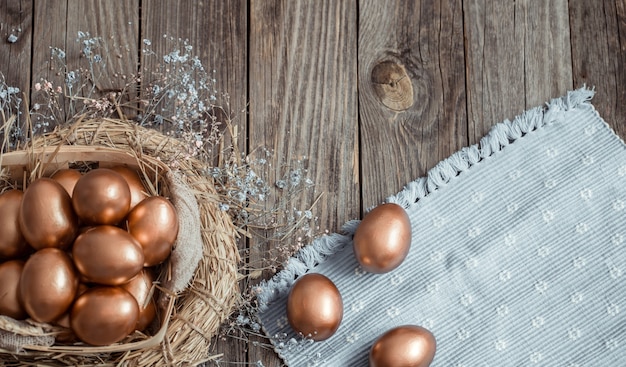 Huevos de Pascua dorados sobre superficie de madera