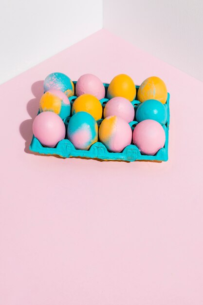 Huevos de Pascua en estante azul en mesa rosa