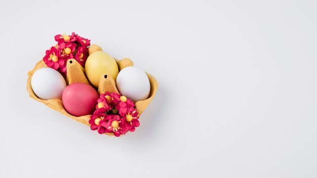 Huevos de Pascua en estante con flores