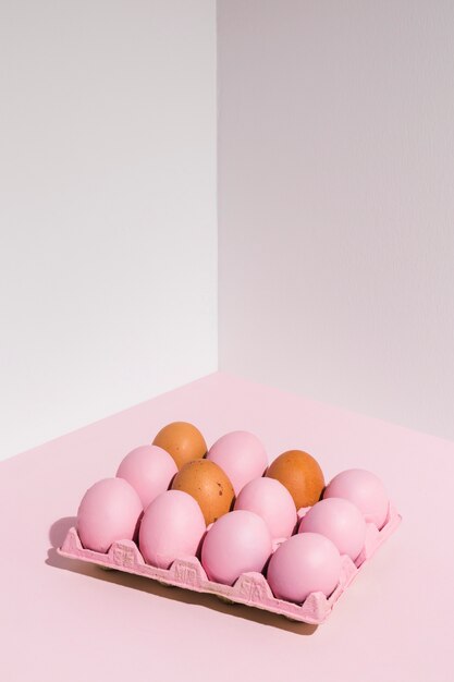 Huevos de Pascua en estante rosa en mesa de luz