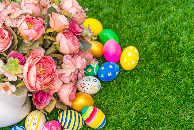 Huevos de Pascua con la flor artificial de la hierba verde fresca