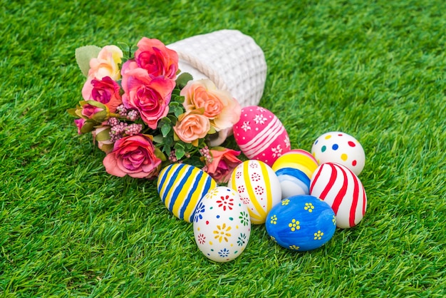 Foto gratuita huevos de pascua con la flor artificial de la hierba verde fresca