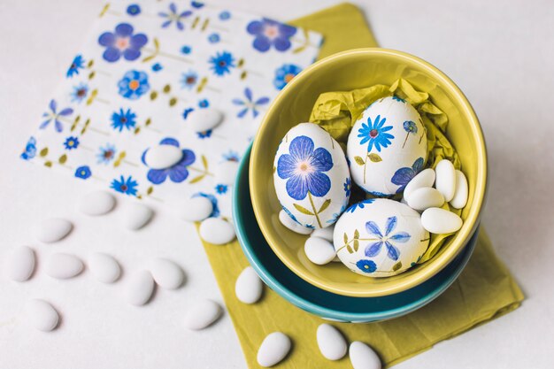 Huevos de Pascua con flores en tazones.