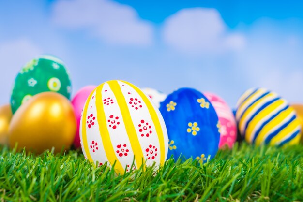 Huevos de Pascua en la hierba verde fresca sobre el cielo azul