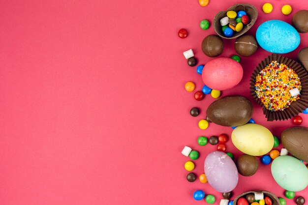 Huevos de Pascua con huevos de chocolate y dulces en mesa