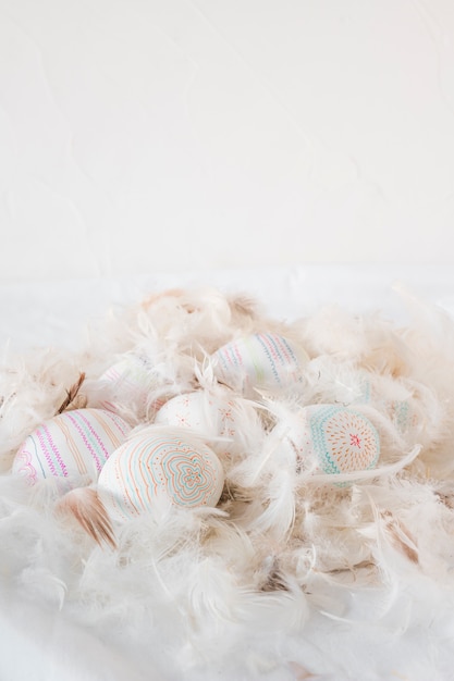 Foto gratuita huevos de pascua entre el montón de plumas