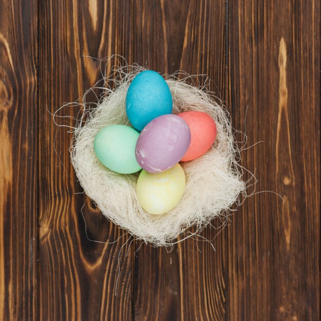 Huevos de Pascua en nido en mesa