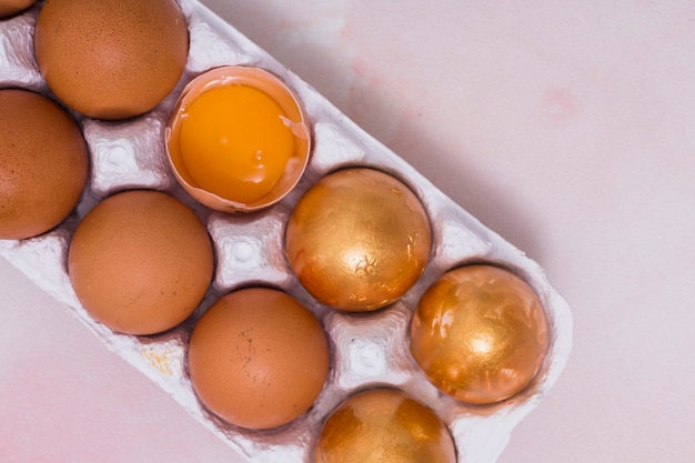 Huevos de Pascua de oro en la rejilla en la mesa de luz
