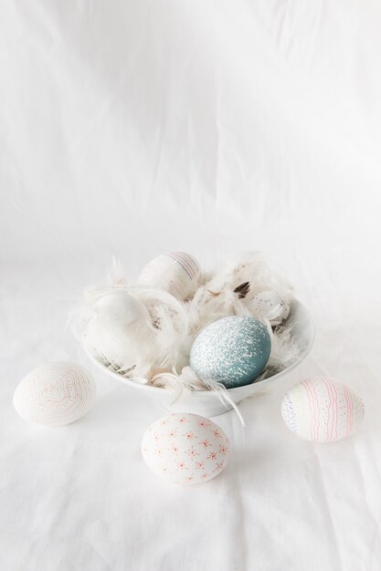 Huevos de Pascua entre plumas en un tazón