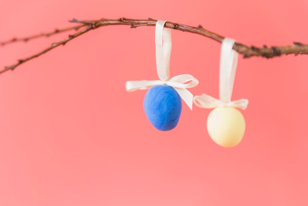 Foto gratuita huevos de pascua que cuelgan en la ramita