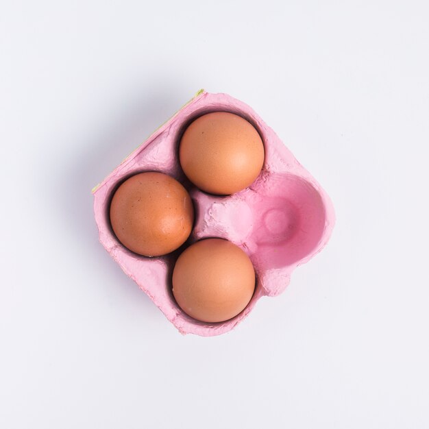 Huevos de Pascua en recipiente rosa