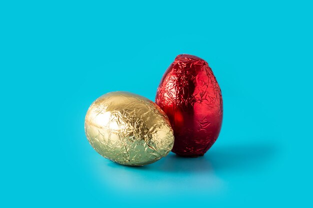 Huevos de Pascua rojos y dorados sobre fondo azul.