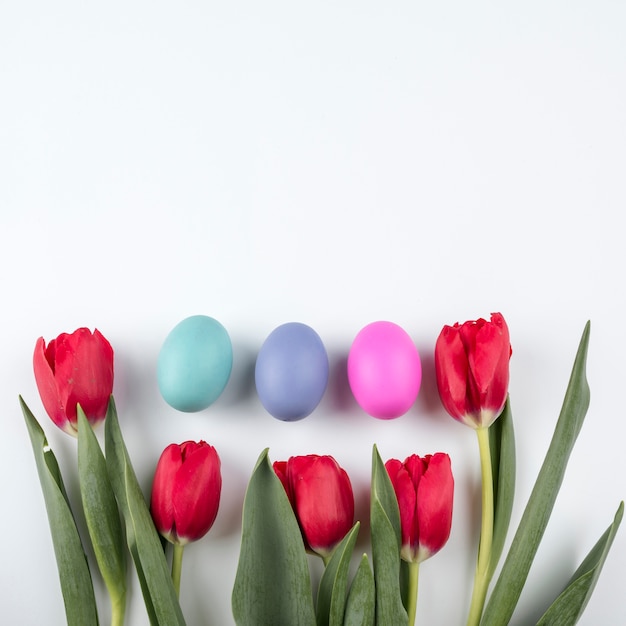 Huevos de Pascua con tulipanes en mesa