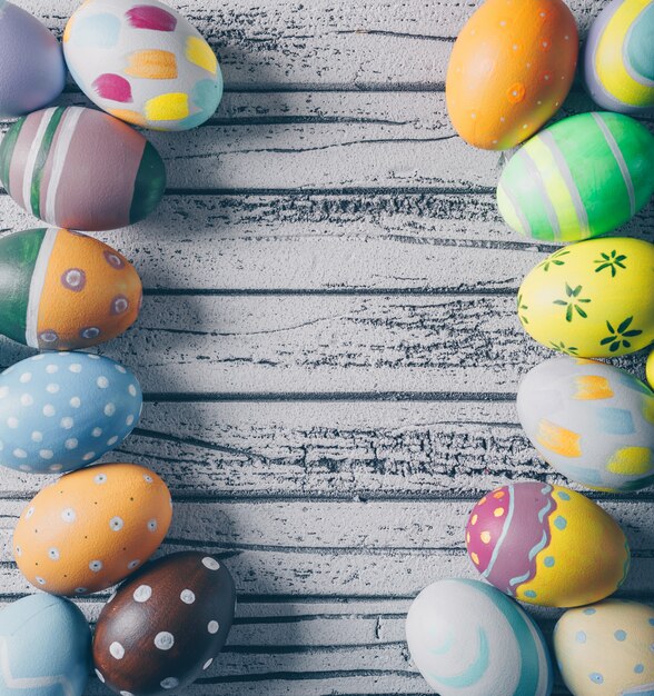 Huevos de Pascua vista superior sobre fondo de madera clara. espacio vertical para texto