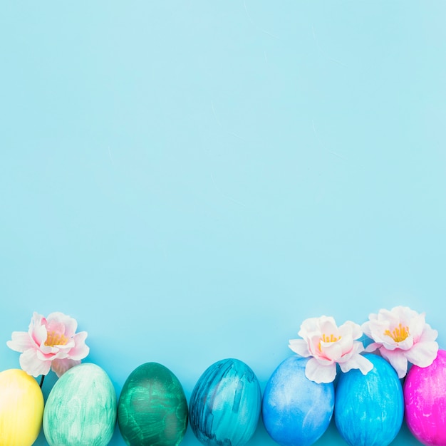 Huevos pintados con flores sobre fondo azul