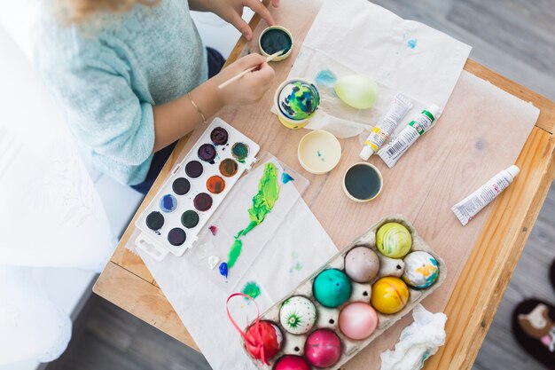 Huevos de pintura infantil en la mesa