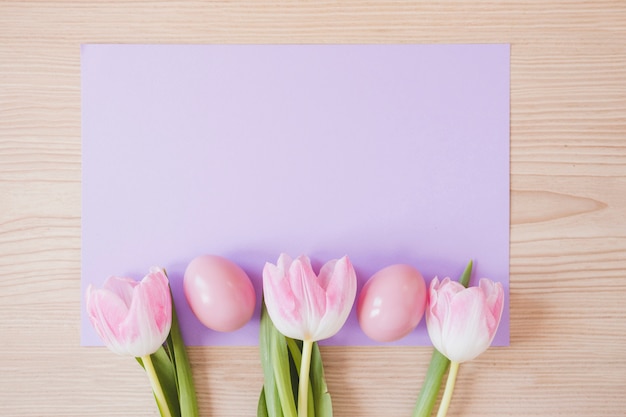 Huevos rosas y tulipanes en papel