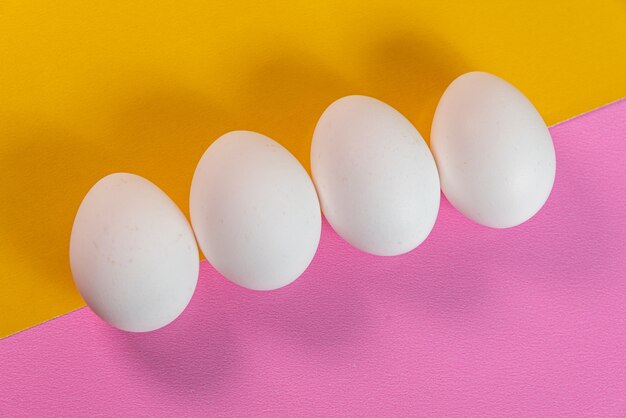 Huevos en la superficie amarilla y rosada.