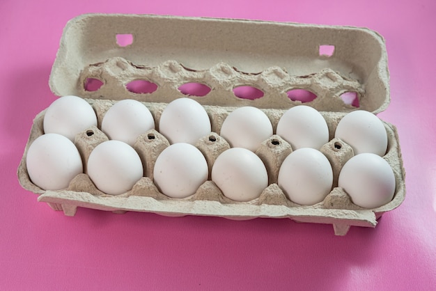 Foto gratuita huevos en la superficie rosa