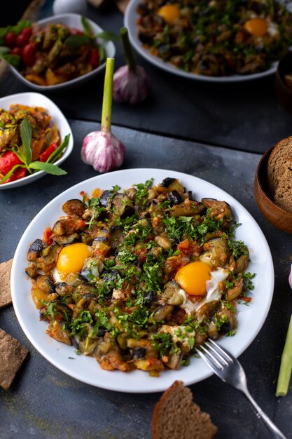 huevos verduras cocidas saladas con pimienta junto con panes de pan dentro de un plato blanco