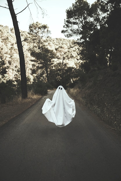 Humano en traje fantasma levitando en la ruta del campo