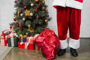 Foto gratuita humano en traje de santa cerca del árbol de navidad