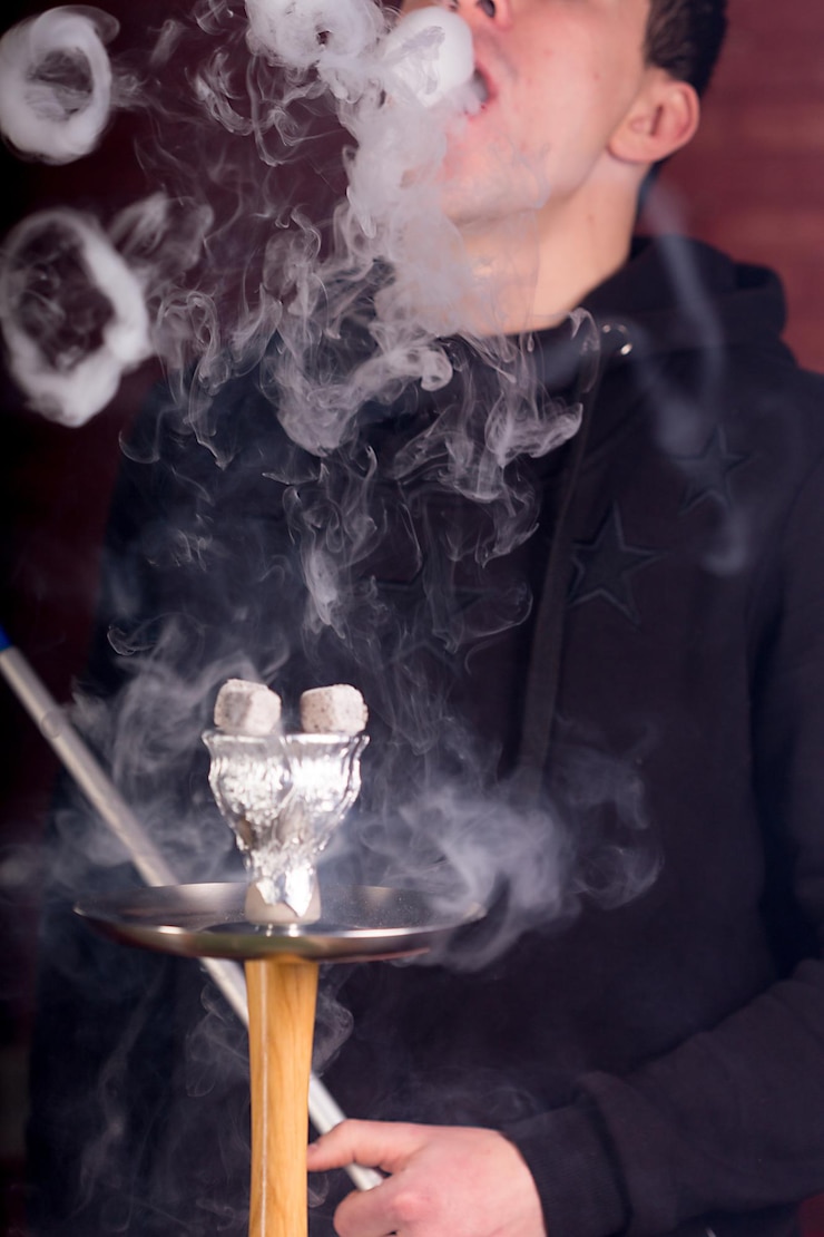 Foto gratuito humo de cachimba sobre fondo oscuro