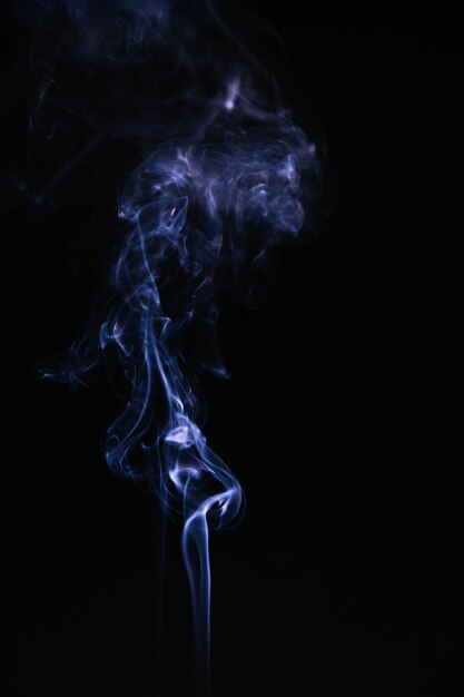 Humo ondulado azul sobre fondo negro