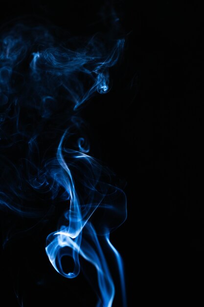 Humo ondulado azul sobre fondo negro