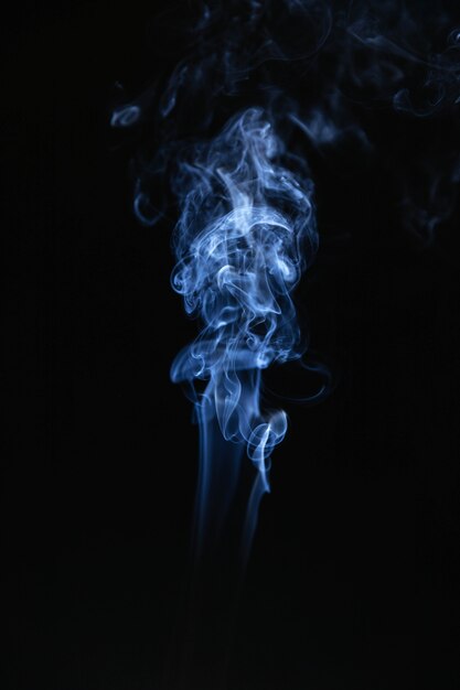 Humo ondulado azul sobre fondo negro