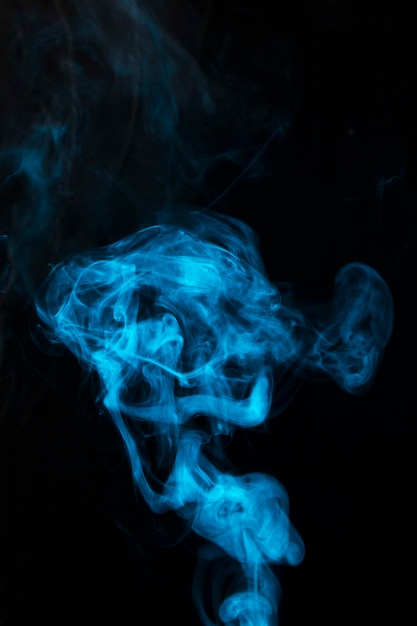 Humo ondulado de remolino azul sobre fondo negro