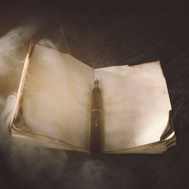 Foto gratuita humo sobre cuaderno antiguo y pluma de tinta