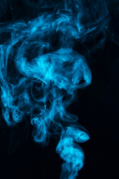 Humo de vapor azul extendido contra el fondo negro