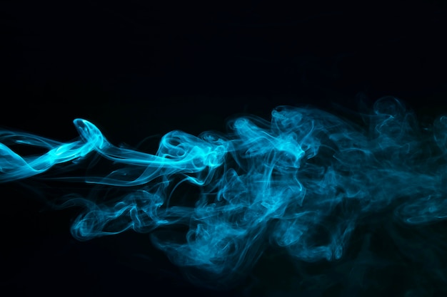 Humo de vapor azul sobre fondo negro