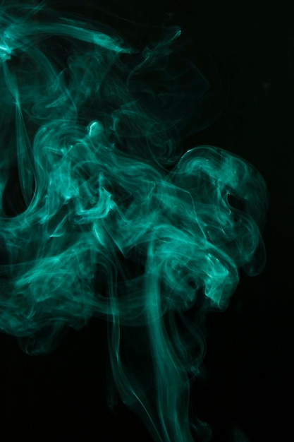 Humo verde tenue extendido sobre fondo negro