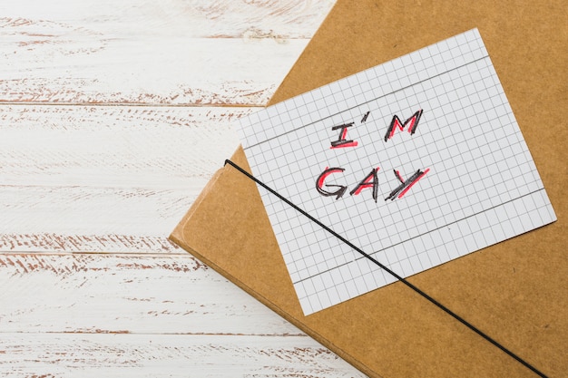 I inscripción gay en papel contra caso de documento.